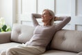 Happy middle aged retired woman relaxing on comfortable sofa. Royalty Free Stock Photo