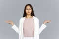 Calm healthy indian business woman meditating on grey studio background