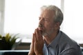 Hopeful old man hold hands in prayer praying at home Royalty Free Stock Photo