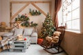 Calm image of interior modern home living room decorated christmas tree and gifts, sofa, table covered with blanket. Royalty Free Stock Photo