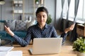 Calm Indian woman with closed eyes meditating at workplace