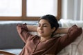 Calm Indian woman relax at home breathe fresh air