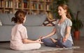 Child girl in lotus pose on floor and meditating with closed eyes with mom Royalty Free Stock Photo