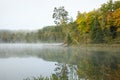 Calm lake and colorful trees in northern Minnesota on a misty autumn morning Royalty Free Stock Photo