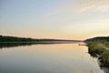 Calm lake at dawn in windless weather