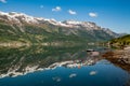 A calm lake by the road in Norway, the water surface is like a mirror, reflecting the blue sky and white clouds Royalty Free Stock Photo