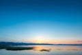 Calm Lake Sevan in Armenia in the rays of the rising sun from behind Royalty Free Stock Photo