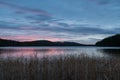 Calm lake surrounded by the forest and hills with the pink sunset in background in Sweden Lapland Royalty Free Stock Photo