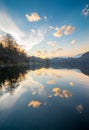 Calm lake water, cloudy sky reflections, sunset colors Royalty Free Stock Photo