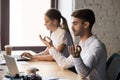 Calm male employee sit near computer meditating at workplace