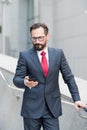 Calm man looking at the smartphone while reading messages