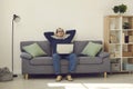 Calm mature man with eyes closed relaxing on comfortable couch with laptop