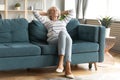 Calm mature 50s woman rest on comfortable sofa