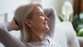 Calm mature woman relax on couch daydreaming Royalty Free Stock Photo