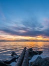 Calm and meditation concept. Sunset on the lake, stones and old trees in the foreground, quiet water, cloudless sky Royalty Free Stock Photo