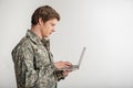 Calm military guy having laptop in hand