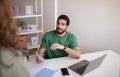 Calm millennial muslim man ceo with laptop talking to manager with documents