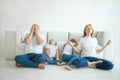 Calm mother with closed eyes meditating in lotus pose on floor, stressed father and two tired children in living room at home Royalty Free Stock Photo
