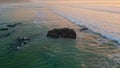 Calm ocean evening scenery with foamy surf rolling to empty coastline drone view