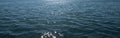 Calm ocean surface with sunlight reflected on ripples backdrop Royalty Free Stock Photo