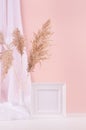 Calm pastel interior with white decoration - blank square frame for text or design, fluffy reeds, curtain on white wood table. Royalty Free Stock Photo