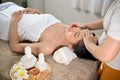 Calm and peaceful Asian woman getting facial treatment massage by a professional masseur Royalty Free Stock Photo