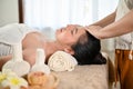 Calm and peaceful Asian woman getting facial treatment massage by a professional masseur Royalty Free Stock Photo