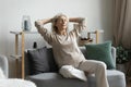 Calm peaceful middle aged mature hoary woman relaxing on cozy couch. Royalty Free Stock Photo