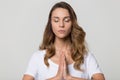 Calm peaceful woman with closed eyes meditating, practicing yoga