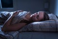 Calm and peaceful woman sleeping in bed in dark bedroom. Lady asleep at home in the middle of the night. Royalty Free Stock Photo