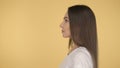 Calm peaceful woman on yellow background in studio isolated. Middleweight woman in basic white t-shirt