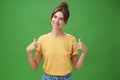 Calm and polite friendly-looking skillful young female coworker in yellow t-shirt pointing at herself self-assured