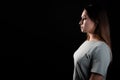 A calm portrait of a young brunette in profile, looking forward. Contour light, copy the space on the left,