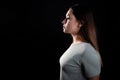 A calm portrait of a young brunette in profile, looking forward. Contour light, copy the space on the left,