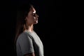 A calm portrait of a young brunette in profile, looking forward. Contour light, copy the space on the right,