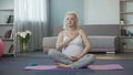 Calm pregnant woman listening to sensations and touches of baby in her belly