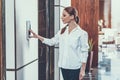 Waist up of calm long haired woman pushing the elevator button Royalty Free Stock Photo