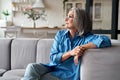 Calm relaxed mature older woman relaxing sitting on couch at home. Royalty Free Stock Photo