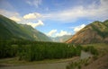 A calm river flowing through a picturesque valley surrounded by beautiful mountain ranges Royalty Free Stock Photo