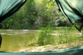 Calm river with forest on bank, view from tent