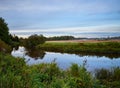 Calm river with reflections against a cloudy sky