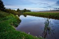 Calm river with reflections against a cloudy sky