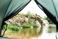 Calm river with rocky bank, view from tent