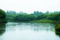 Calm river with trees on the shores in rainy autumn day. Autumn landscape Royalty Free Stock Photo