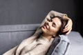 Happy woman relaxing on comfortable soft sofa enjoying stress free weekend at home Royalty Free Stock Photo