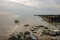 calm sea beach in summer with large rocks and wooden poles from old breakewater in the sea Royalty Free Stock Photo