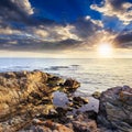 Calm sea with boulders on coast at sunset Royalty Free Stock Photo