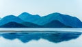 Calm sea with distant mountains and reflection in water Royalty Free Stock Photo