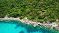 Calm sea near tropical volcanic island. Drone view of peaceful water of blue sea near stony shore and green jungle of volcanic Koh Royalty Free Stock Photo