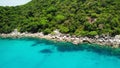 Calm sea near tropical volcanic island. Drone view of peaceful water of blue sea near stony shore and green jungle of volcanic Koh Royalty Free Stock Photo